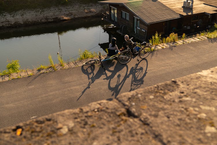 Cyclists Sitting On Lakeshore In Dusseldorf, Germany