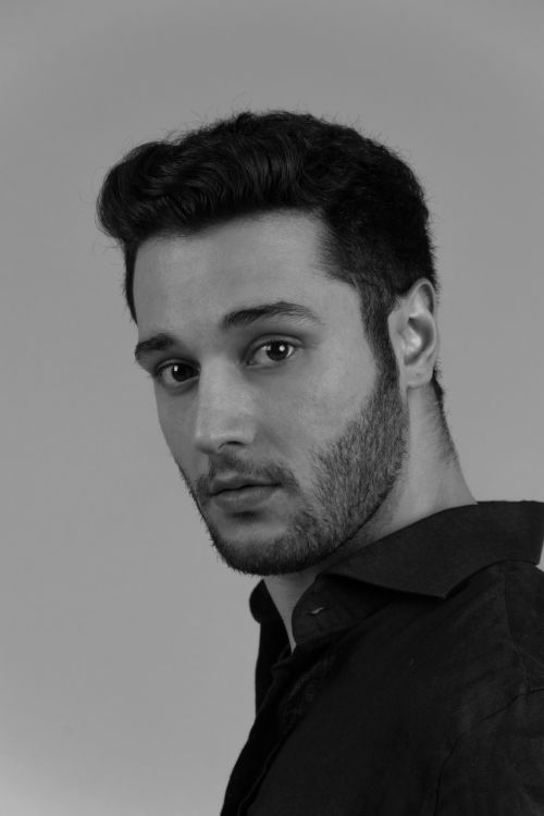 Free Striking black and white portrait of a young man with a beard, posing against a neutral background. Stock Photo