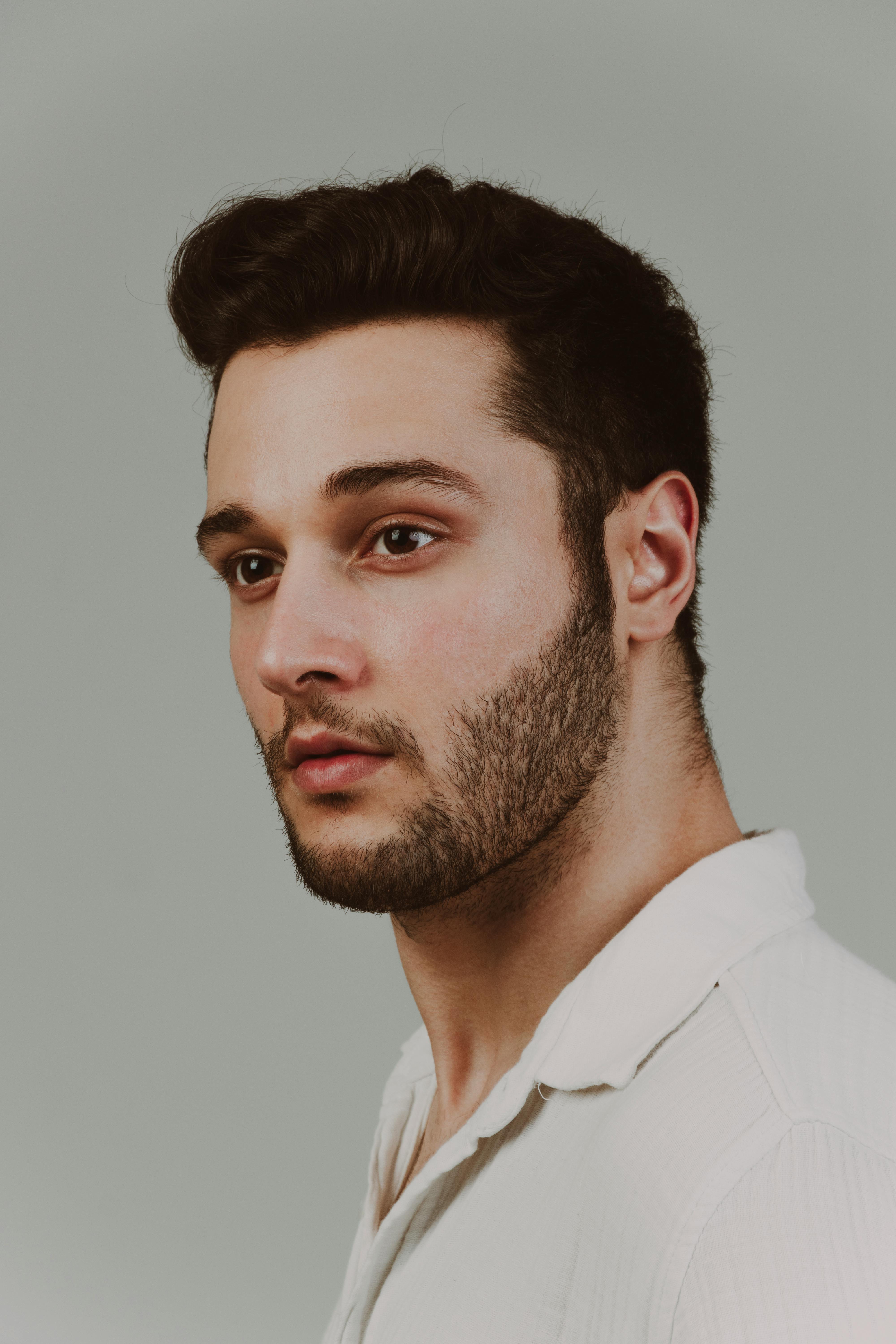 Profile portrait of a handsome young man against a neutral backdrop.