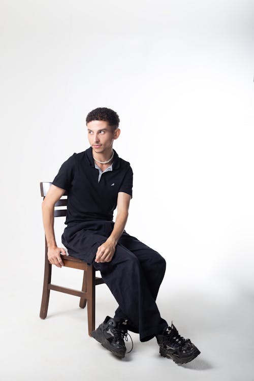 Man in Black Clothes Sitting and Posing on Chair