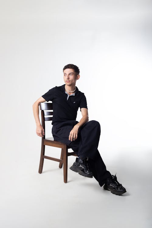 Man in Black Clothes Posing on Chair
