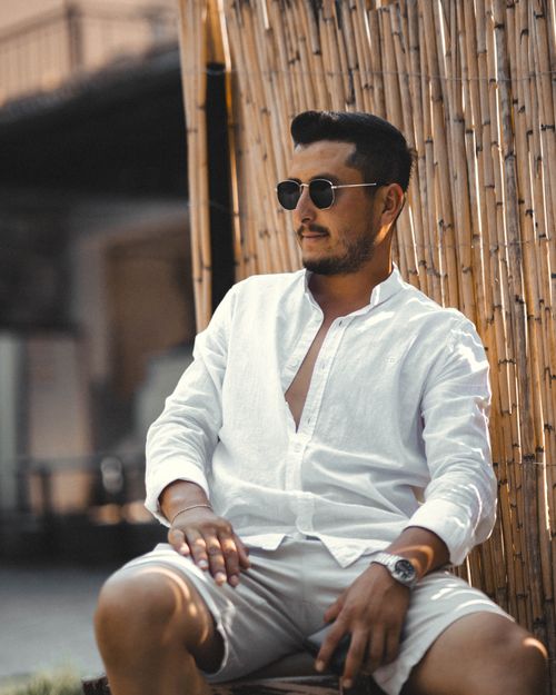 Free Casual portrait of a man in sunglasses relaxing by a bamboo fence in summer. Stock Photo
