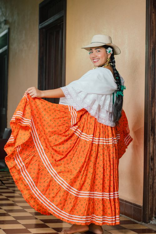 Free Woman in traditional Panamanian dress smiling indoors with a straw hat. Stock Photo