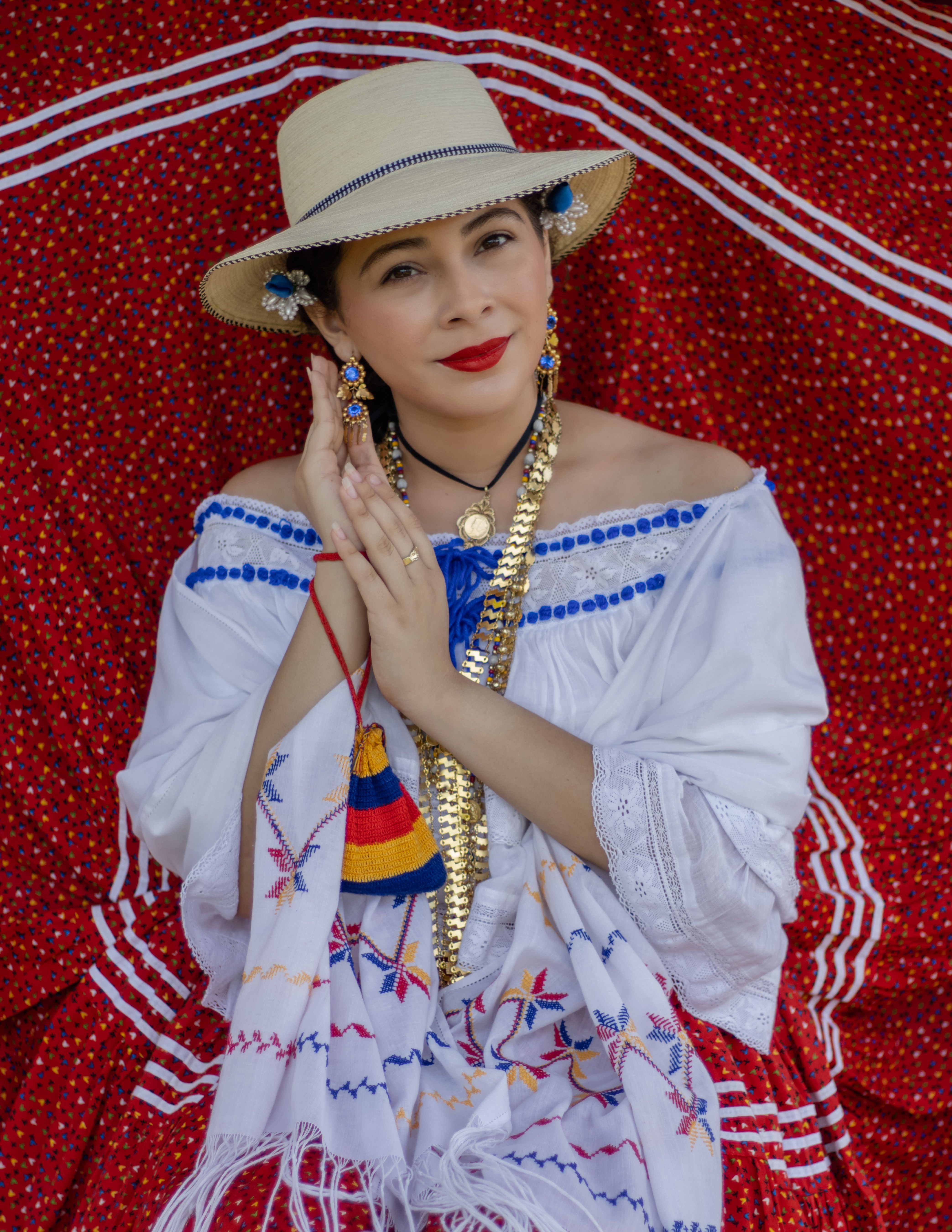 A woman in traditional Panamanian clothing with vibrant red skirt and hat, embodying cultural heritage.
