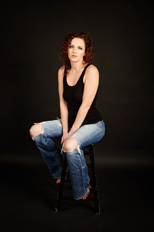 Studio Shot of a Young Woman Wearing Ripped Jeans 