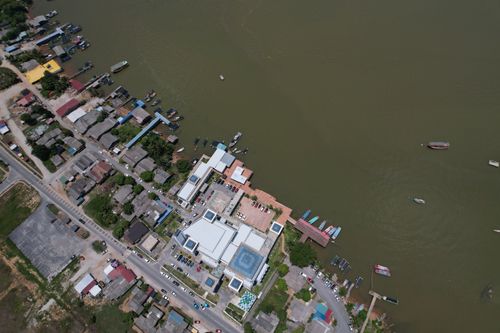 Free Drone shot of a coastal town with harbor and buildings along the shoreline. Stock Photo
