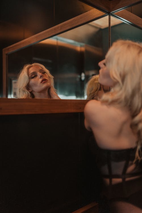 Beautiful Blonde Woman and Her Reflection in Mirror