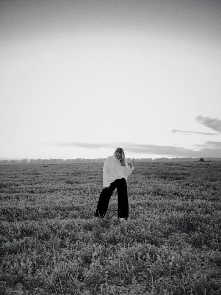 Woman In Turtleneck Sweater Standing On Meadow