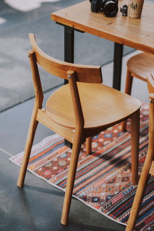 Free A simple wooden chair on a vibrant carpet adds charm to a modern indoor setting. Stock Photo