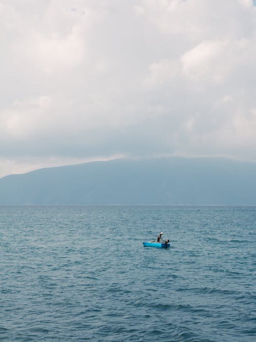 Foto profissional grátis de azul, barco de pesca, costa