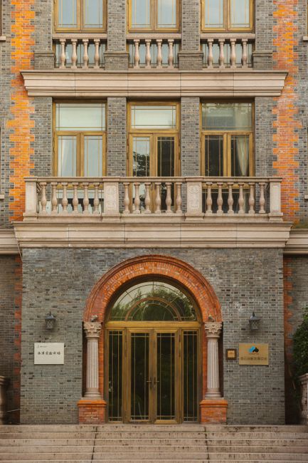 Stunning neoclassical architectural facade with ornate columns and glass doors.