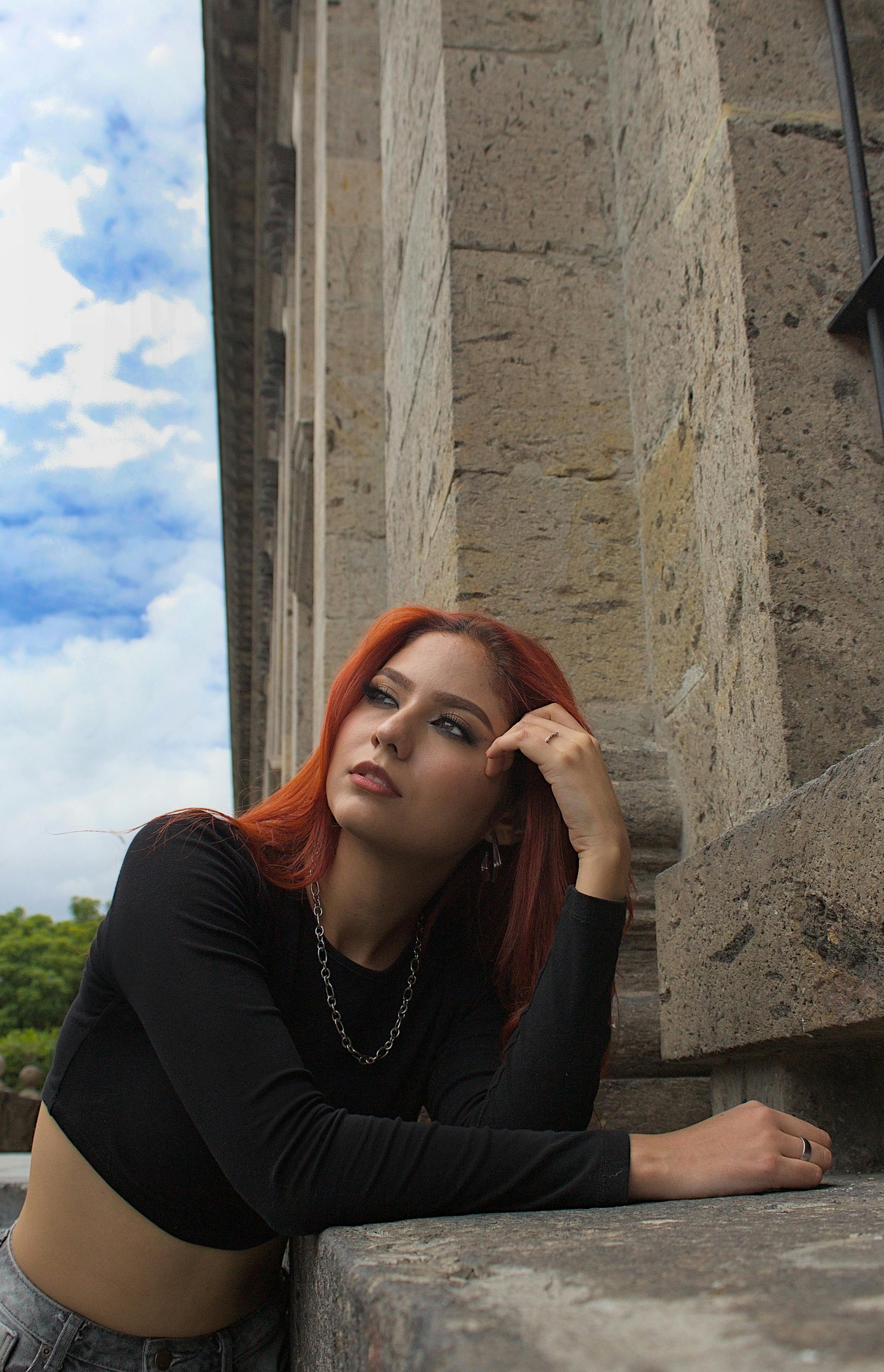 young redhead woman posing in black long sleeved crop top