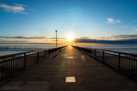 Beautiful sunrise view from the pier in Christchurch, New Zealand with ocean horizon.
