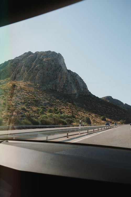 Free A beautiful mountain landscape seen through a car windshield during daytime travel. Stock Photo
