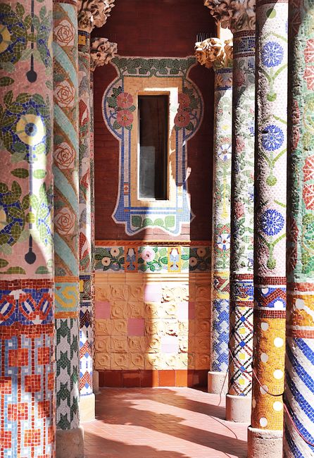 Colorful mosaic columns in Palau de la Música Catalana, Barcelona, showcasing art nouveau architecture.