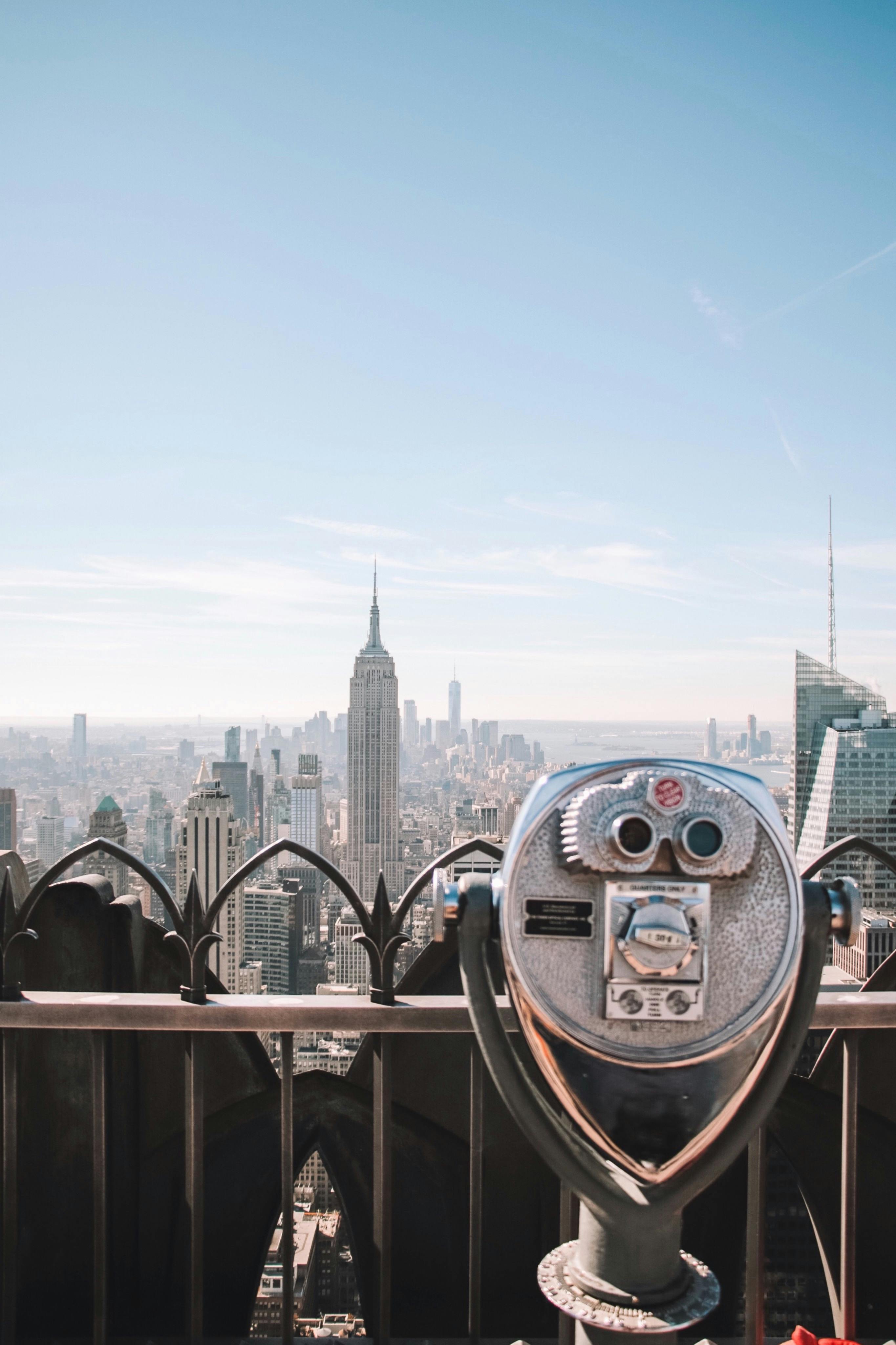 Capture of New York City skyline featuring iconic Empire State Building viewed from a rooftop.