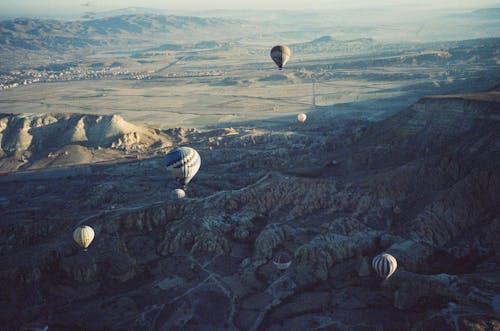 Hot Air Balloons Flying Above Mountains