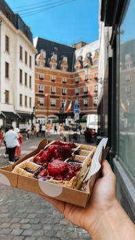 Street scene in Brussels featuring a Belgian waffle with strawberries and chocolate.