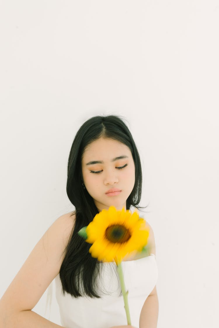 Young Woman Holding A Sunflower