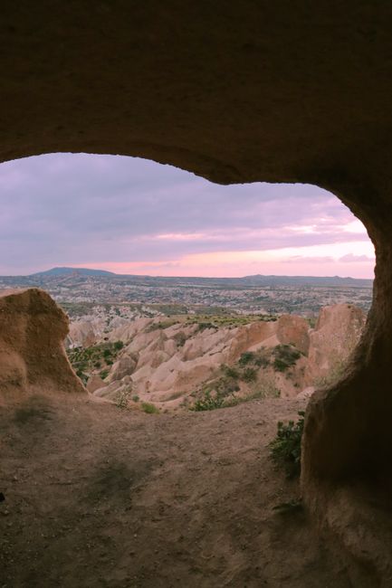 Beautiful sunset view from a cave overlooking Cappadocia's unique rock formations.