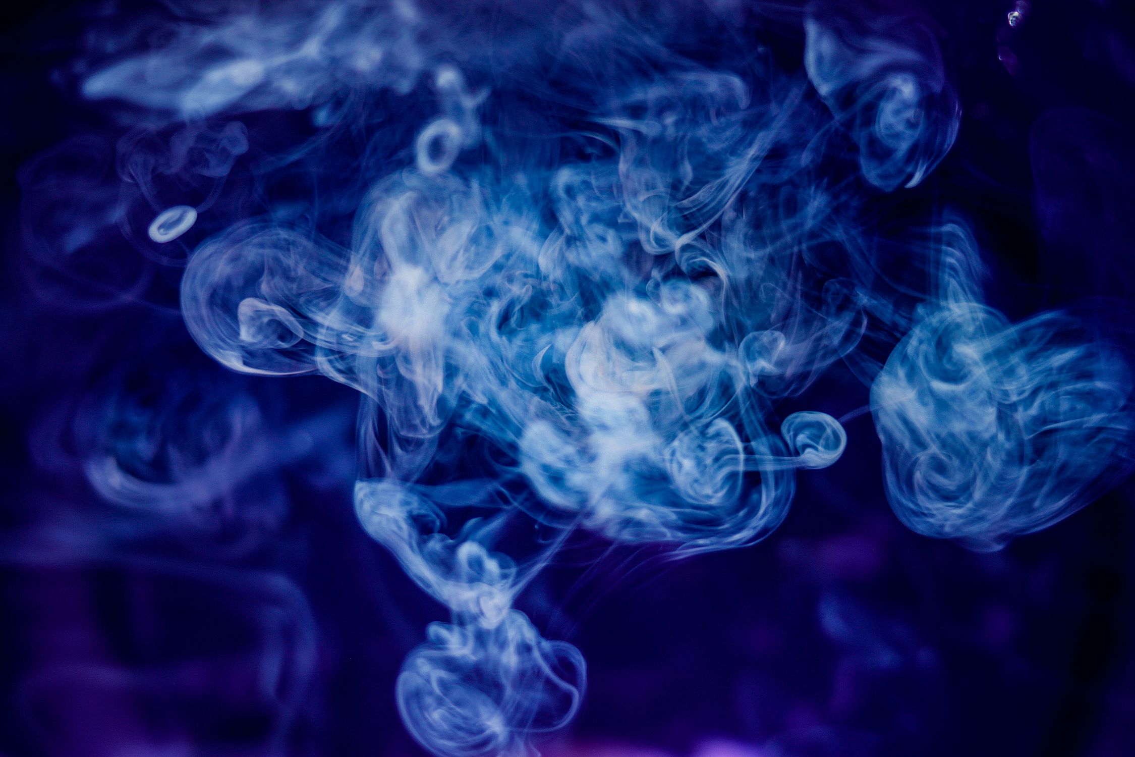 Clouds of Spiralling Smoke against Deep Blue Background · Free Stock Photo
