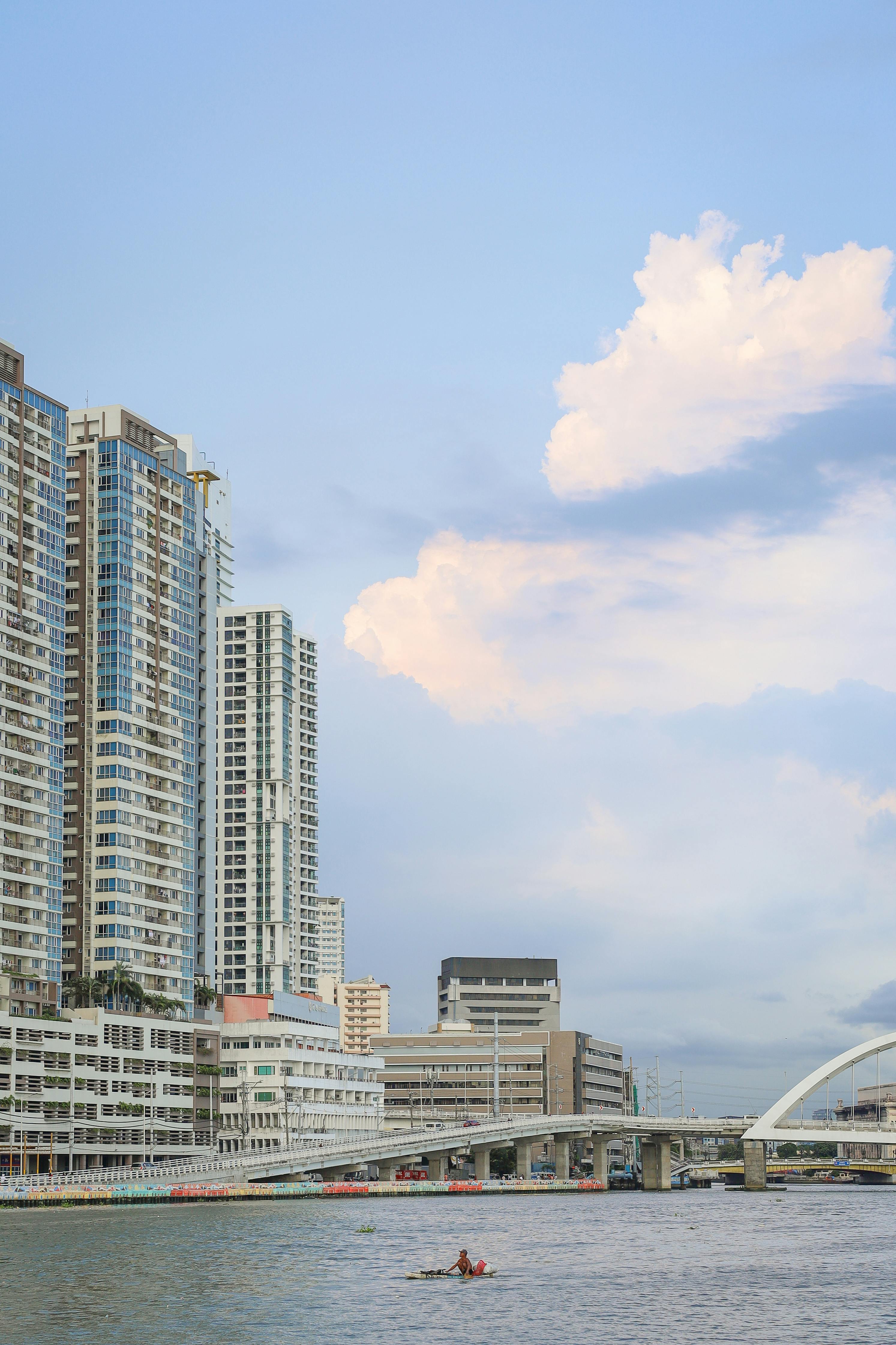 Explore the vibrant Manila skyline over the Pasig River with modern architecture and serene waters.