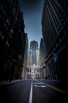 Majestic view of Chicago skyscrapers along an empty street at dusk, showcasing urban architecture.
