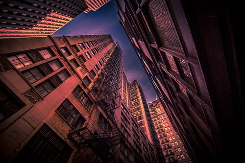 Free Low angle shot of tall city skyscrapers with fire escape stairs at dusk. Stock Photo