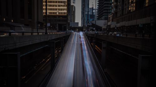 Free Long exposure of city highway at night featuring light trails and modern buildings. Stock Photo