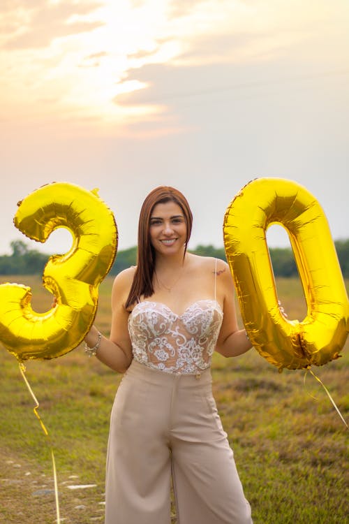 Smiling Woman Standing with Birthday Balloons