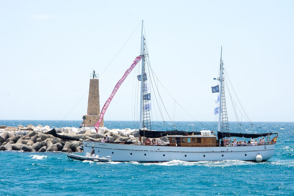 Unforgettable Tenerife Ecoyacht Tour for Whale Watching Review: An Unforgettable Eco-Luxury Experience Review 2026 - A beautiful yacht sailing near a lighthouse under a clear sky in Marbella, Spain.