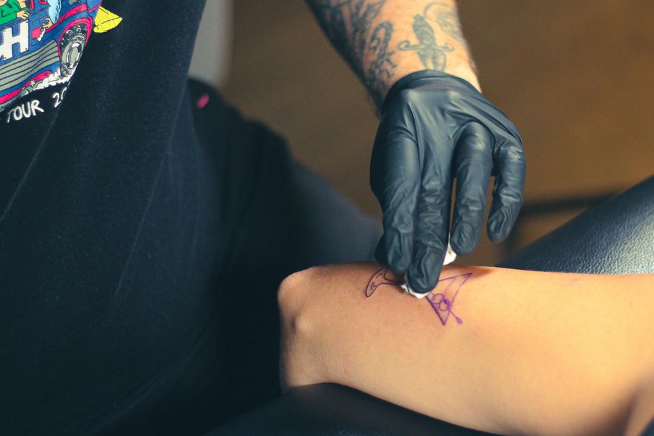 Fresh tattoo being cleaned as part of proper aftercare instructions Fresh tattoo being cleaned as part of proper aftercare instructions