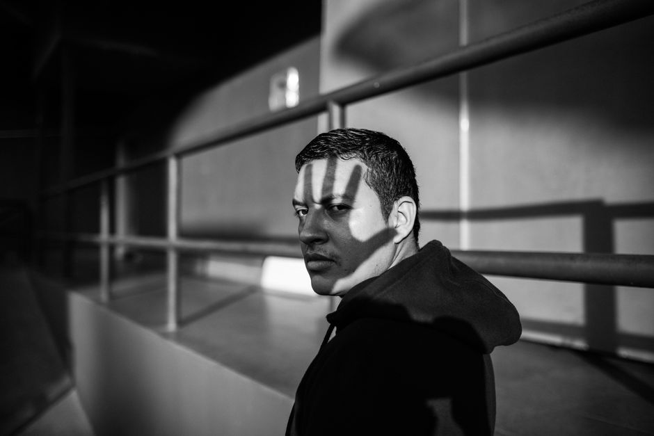 Black and white portrait of a man in shadows, conveying mystery and depth.