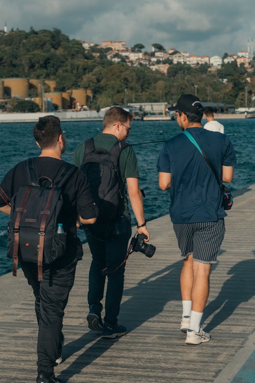 Men Walking on Pier on Sea Shore