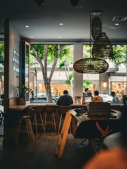 Chic urban café scene with patrons enjoying a relaxed atmosphere, modern decor, and warm lighting.
