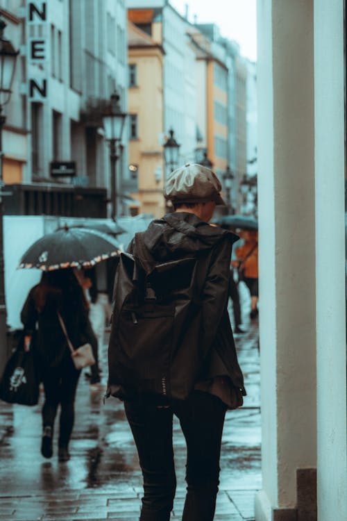Woman in Jacket Walking in Alley in City in Rain