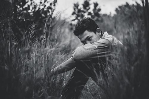 Monochrome Photo Of Man Sitting On Grass