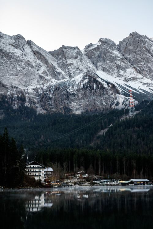 Free Beautiful winter landscape with snowcapped mountains and a serene lake reflecting the scenic view. Stock Photo