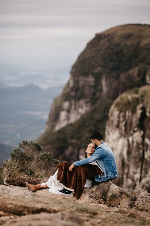 Couple Sitting on Rocks on Hilltop