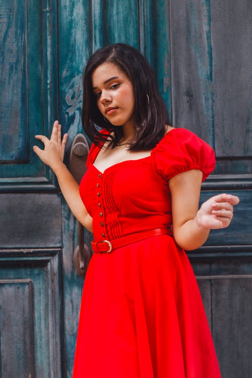 Young Woman in Red Dress in front of Old Wooden Door