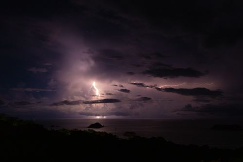 Free A breathtaking view of a thunderstorm over the ocean with dramatic lightning illuminating the clouds. Stock Photo