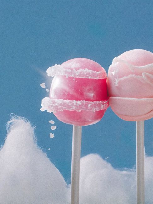 Two pink lollipops with fluffy clouds set against a vibrant blue sky in Montréal.