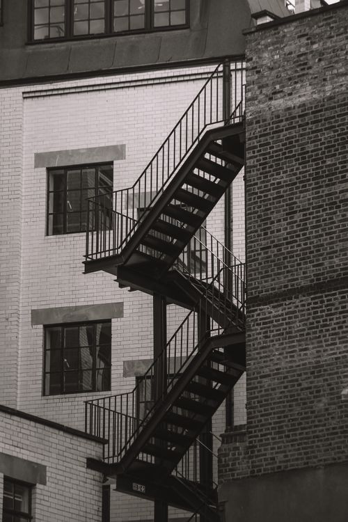 Free Black and white photo of a fire escape on a London brick building. Stock Photo