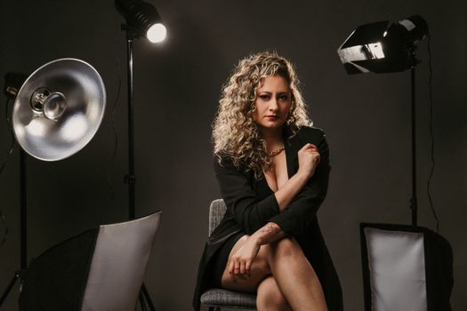 Woman in black blazer posing in a photo studio