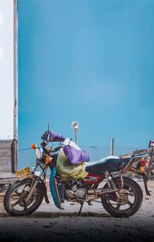 A vintage motorcycle parked outside with clear skies. Ideal for urban and travel themes.