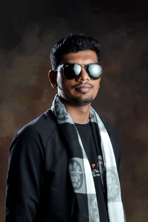 Free Fashionable portrait of a young South Asian man in sunglasses and scarf, set against a dark background. Stock Photo