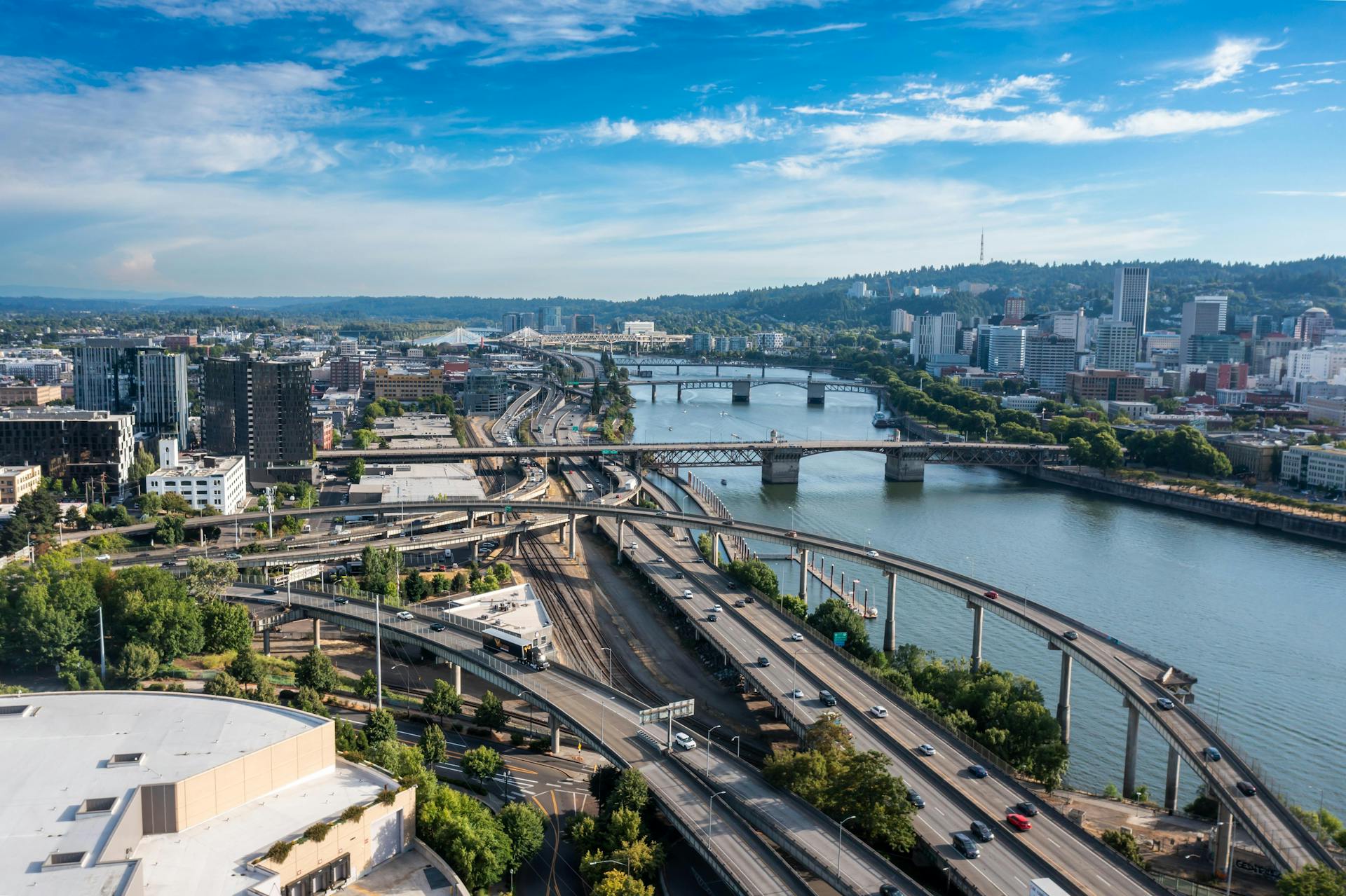 Aerial view of Portland cityscape featuring bridges over a river and urban landscapes on a clear day.