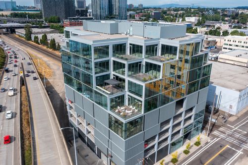 Free Aerial view of a modern cube-style office building in a bustling urban area. Stock Photo