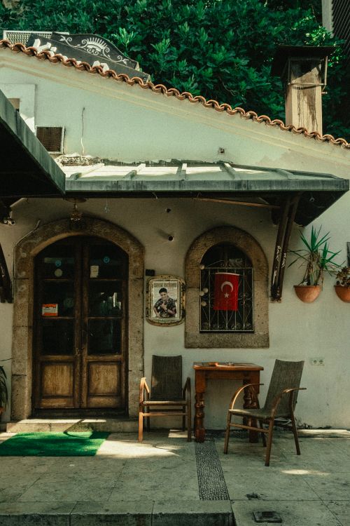 Free Charming Turkish cafe entrance with wooden doors, chairs, and a national flag. Stock Photo