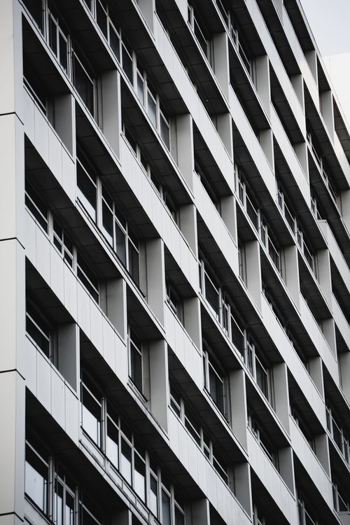 Free A close-up vertical shot of a modern residential building facade in black and white. Stock Photo